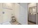 Bright laundry room with tile floor, front load washer, laundry basket and a mirror reflecting bathroom at 1442 Ironbark Bnd, Davenport, FL 33837