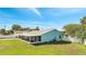 Back exterior view showing the home's full screened in patio with a spacious green yard, and fencing at 161 Laurel Way, Kissimmee, FL 34743