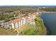 Aerial view of a condo building with a pool overlooking a lake and green spaces at 16300 County Road 455 # 607, Montverde, FL 34756