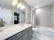 Well-lit bathroom with gray cabinets, a quartz countertop, and a shower-tub combination at 16300 County Road 455 # 607, Montverde, FL 34756