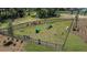 Aerial view of a fenced dog park with agility equipment and benches for pet owners at 175 River Front Way, Edgewater, FL 32141