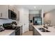 Modern kitchen with stainless steel appliances, grey cabinets, and white countertops at 175 River Front Way, Edgewater, FL 32141