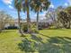 Landscaped backyard features lush greenery, palm trees, and a screened pool area, creating a private outdoor oasis at 19 Meadowlake Ct, Winter Haven, FL 33884