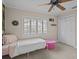 Bedroom featuring shuttered windows, ceiling fan, closet doors and pink ottoman at 19 Meadowlake Ct, Winter Haven, FL 33884