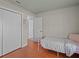 Bright bedroom featuring hardwood floors, closet doors, and an ensuite at 19 Meadowlake Ct, Winter Haven, FL 33884