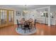 Bright dining room adjacent to a living space, featuring a round table and elegant chandelier at 19 Meadowlake Ct, Winter Haven, FL 33884