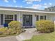 Close up of charming front porch with brick detail, gray shutters, and welcoming front door at 19 Meadowlake Ct, Winter Haven, FL 33884