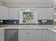 Bright kitchen featuring white cabinetry, modern appliances, and open shuttered window at 19 Meadowlake Ct, Winter Haven, FL 33884