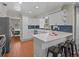 Bright kitchen with white cabinetry, modern appliances, peninsula seating, and blue tiled backsplash at 19 Meadowlake Ct, Winter Haven, FL 33884