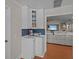 Bright kitchen featuring white cabinetry, stainless mixer, and view into the living room at 19 Meadowlake Ct, Winter Haven, FL 33884