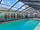 Large screened pool with a clear view of home's doors and windows, and lounge area on the patio in the backyard at 19 Meadowlake Ct, Winter Haven, FL 33884