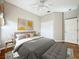 Comfortable bedroom featuring a stylish gray bed, bench, light wood nightstand and contemporary artwork at 21636 King Henry Ave, Leesburg, FL 34748
