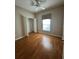 Bedroom with hardwood floors, ceiling fan, closet, and ample natural light at 21636 King Henry Ave, Leesburg, FL 34748