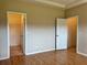 Open bedroom with wood floors and closet/bathroom access at 21636 King Henry Ave, Leesburg, FL 34748