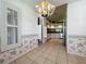Bright dining room with tiled floors, floral wallpaper and a modern hanging light at 21636 King Henry Ave, Leesburg, FL 34748
