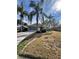 Exterior view of a single-story home, featuring a tidy lawn and lush palm trees at 21636 King Henry Ave, Leesburg, FL 34748