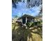 Exterior view of a cozy home with a screened-in patio, surrounded by well-maintained landscaping at 21636 King Henry Ave, Leesburg, FL 34748