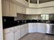 Bright kitchen features tile floors, white cabinetry, and black countertops at 21636 King Henry Ave, Leesburg, FL 34748