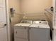 Functional laundry room with washer, dryer, and wire shelving for storage at 21636 King Henry Ave, Leesburg, FL 34748