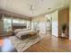 Staged bedroom with ceiling fan and large windows showcasing backyard views at 21636 King Henry Ave, Leesburg, FL 34748