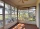 Enclosed sunroom with tile floors, ceiling fan, and large windows offering great outdoor views at 21636 King Henry Ave, Leesburg, FL 34748