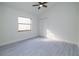 A bright bedroom features a ceiling fan, window and closet with gray wood-look flooring at 2555 Sweetwater Trl, Maitland, FL 32751