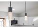 Stylish pendant lights illuminate the kitchen island, complementing the modern white cabinetry and backsplash at 2555 Sweetwater Trl, Maitland, FL 32751