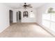 Inviting living room with carpet flooring, a ceiling fan, and arched openings to the kitchen at 2645 Coachman Dr, Deltona, FL 32738