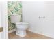 A small powder room with toilet and tropical-themed wallpaper at 2645 Coachman Dr, Deltona, FL 32738