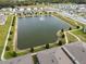 This aerial shot features a pond with fountain, bordered by manicured lawns and the rooftops of surrounding residential properties at 2821 Sunridge Loop, St Cloud, FL 34771