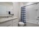 Well-lit bathroom with a granite countertop, a bathtub with a shower, and a white vanity at 2821 Sunridge Loop, St Cloud, FL 34771