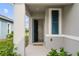 Inviting front porch with a 'Hello' doormat and stylish blue front door and shutter detail at 2821 Sunridge Loop, St Cloud, FL 34771