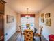 Cozy dining area with a round table, floral chairs, and a view of natural light through the window at 2936 Suber St, The Villages, FL 32163