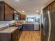 Well-equipped kitchen with stainless steel appliances, dark wood cabinetry, and a view into the living area at 2936 Suber St, The Villages, FL 32163