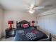 Cozy bedroom with ceiling fan, black furniture set, and bright red lamps on each bedside table at 2936 Suber St, The Villages, FL 32163