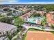 An aerial view captures the community's pool, tennis courts, mature trees, and residential buildings at 3208 Sabal Palms Ct # A, Kissimmee, FL 34747