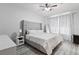 Bedroom featuring a gray upholstered bed, white nightstand, and full length mirror at 3257 Villa Strada Way, Orlando, FL 32835