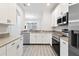 Well-lit kitchen featuring stainless steel appliances, granite countertops, and white cabinetry at 3257 Villa Strada Way, Orlando, FL 32835