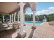 Community pool with a covered seating area, surrounded by lush greenery at 3257 Villa Strada Way, Orlando, FL 32835