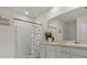 Well-lit bathroom featuring double sinks, white cabinets, and a walk-in shower at 337 Regency Ridge Dr, Davenport, FL 33837