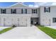 Inviting townhome featuring a gray facade, manicured lawn and individual one car garages at 3374 Private Oak Dr, Apopka, FL 32703