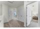 Well-lit hallway with neutral carpet, showcasing a view of other rooms and closet space at 3374 Private Oak Dr, Apopka, FL 32703