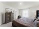 Bright bedroom featuring a dresser with a stylish mirror and neutral color palette at 3380 Private Oak Dr, Apopka, FL 32703