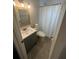 Clean bathroom features a sink, toilet, shower with a curtain and a wall mirror at 3807 March Ave, Orlando, FL 32806