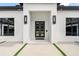 Stylish entryway featuring a modern front door, sconces, a video camera and well-maintained landscaping at 3845 S Stillwood Ln, Lake Mary, FL 32746