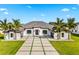 Elegant home with a well-manicured lawn, palm trees, and a modern driveway design at 3845 S Stillwood Ln, Lake Mary, FL 32746