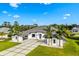 Aerial shot of a pristine white home with lush green lawn, palms, and stylish curb appeal at 3845 S Stillwood Ln, Lake Mary, FL 32746