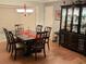 Cozy dining room featuring a dark wood table, a chandelier, and a stylish china cabinet at 3913 Rose Of Sharon Dr, Orlando, FL 32808