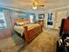 Cozy main bedroom with a wooden bed frame, ceiling fan, and ensuite bathroom at 3913 Rose Of Sharon Dr, Orlando, FL 32808