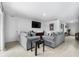 Cozy living room with matching sofas, a wall-mounted TV, and neutral-toned tile flooring at 411 Ridges Dr, Dundee, FL 33838